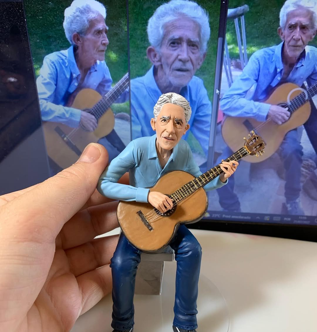 Escultura detalhada de senhor idoso tocando violão com camisa azul