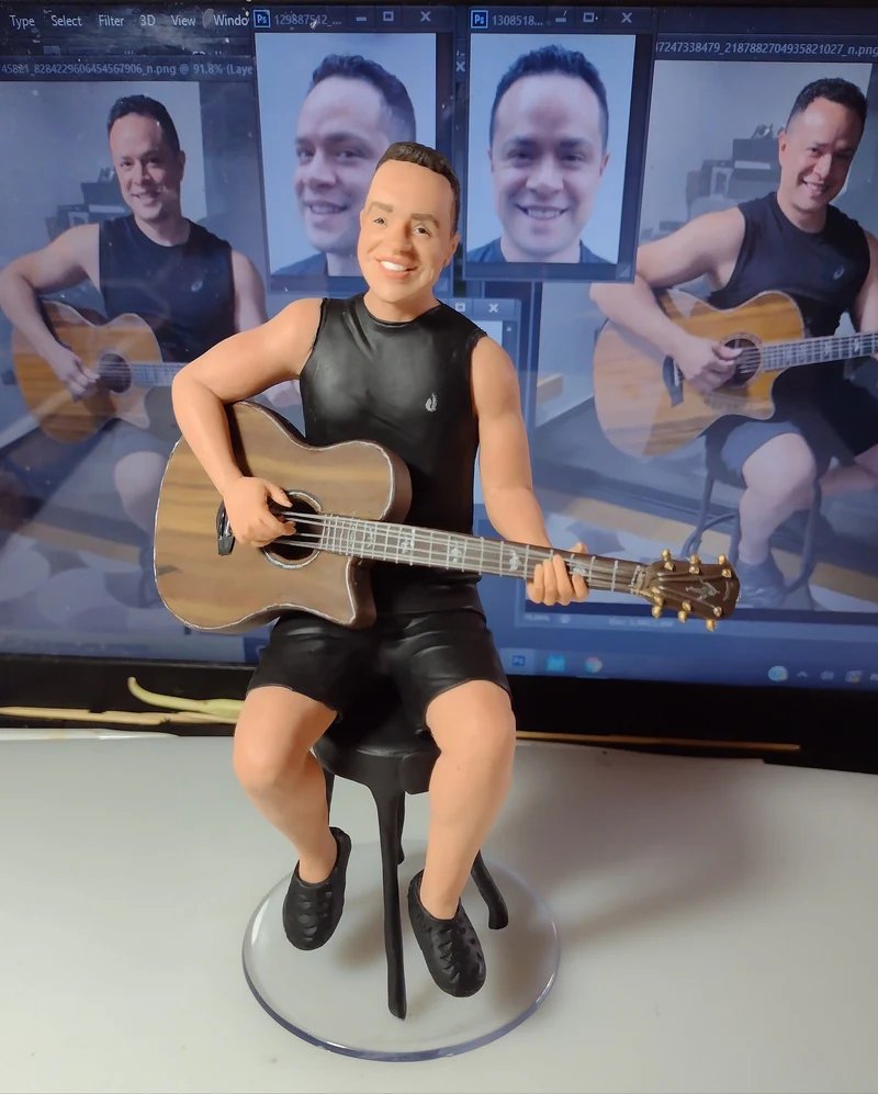 Miniatura esculpida de homem com roupa esportiva tocando violão com a foto original ao fundo